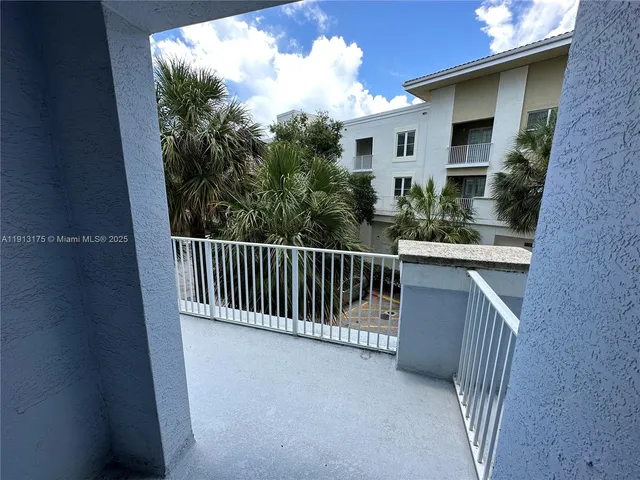 a view of balcony with lots of palm trees