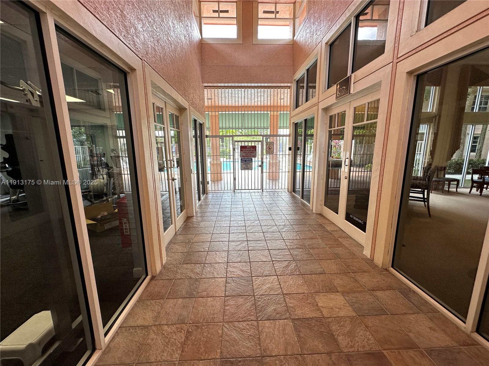 1200 Town Center Drive, Unit 217 Jupiter, FL 33458 - Photo 32 of 37 a hallway with sliding door and chandelier