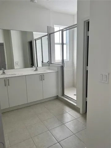 a spacious bathroom with a mirror and a shower