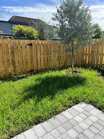 a view of backyard with wooden fence