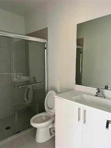 a bathroom with a granite countertop sink toilet and a mirror