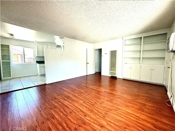a view of empty room with wooden floor and window