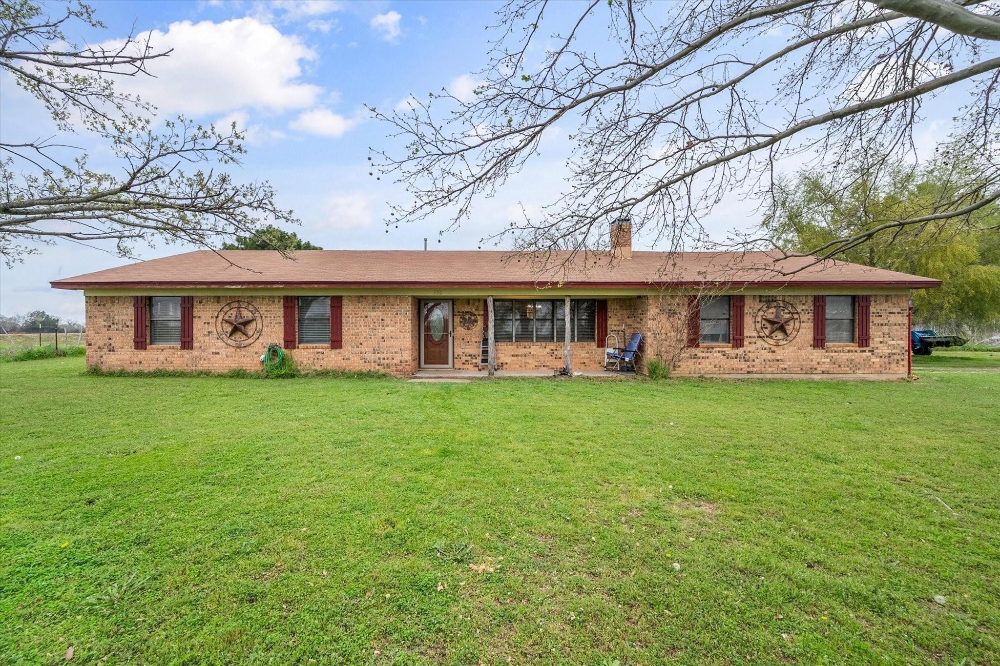 230 Freestone County Road, Unit 141 Streetman, TX 75859 - Photo 20 of 40 a view of a house next to a big yard with large trees