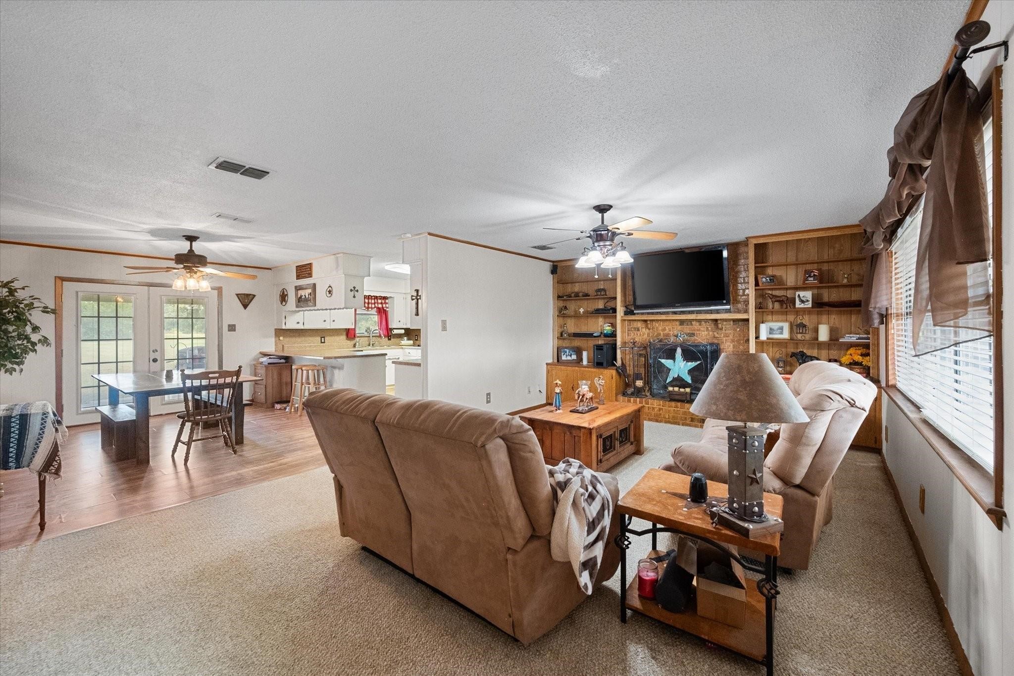 230 Freestone County Road, Unit 141 Streetman, TX 75859 - Photo 8 of 40 a living room with furniture a flat screen tv and kitchen view
