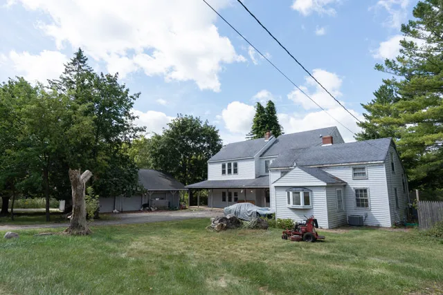 a front view of a house with a garden and trees