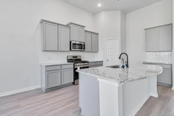 a kitchen with stainless steel appliances granite countertop a sink stove and microwave