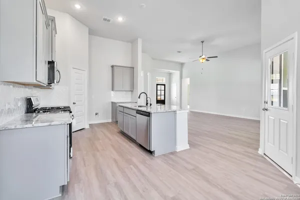 a kitchen with stainless steel appliances granite countertop a sink stove and refrigerator