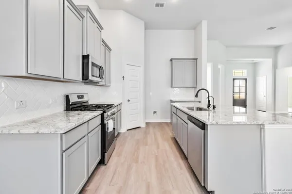 a kitchen with stainless steel appliances granite countertop a sink and stove