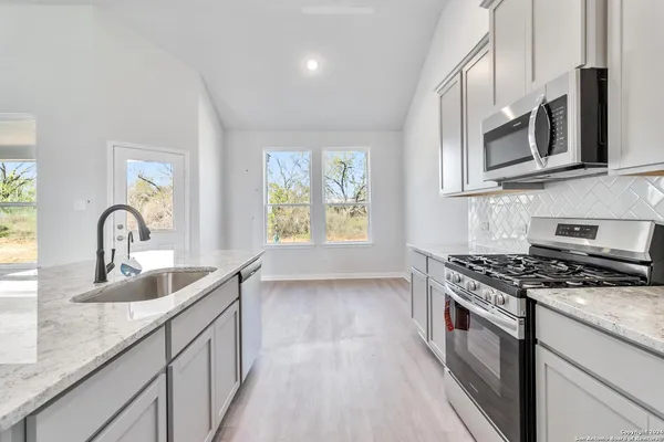 a kitchen with stainless steel appliances granite countertop a sink stove and microwave