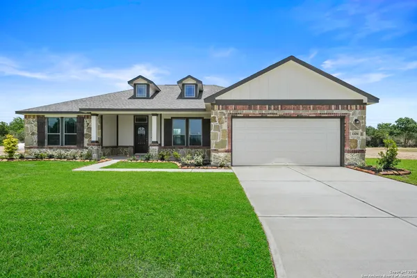 a front view of a house with yard and green space