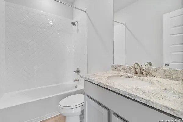 a bathroom with a granite countertop sink a toilet and a bathtub