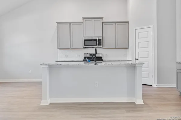 a close view of a sink a microwave and cabinets