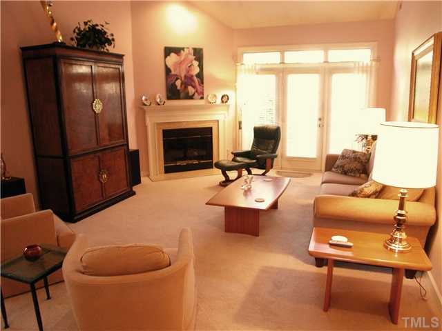 8730 Compass Lane Raleigh, NC 27615 - Photo 3 of 21 Comfortable living room has dramatic vaulted ceiling, gas fireplace w/ marble surround. The property is now empty & a pleasure to show w/new carpet and paint. We decided to keep this image to show how lovely the property was when furnished.