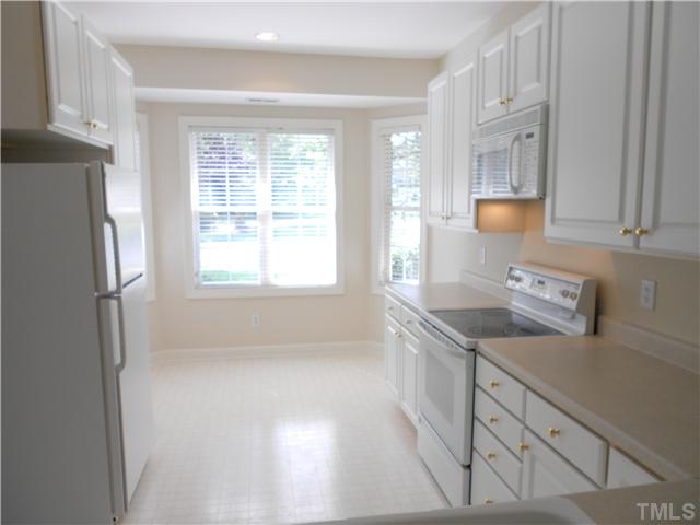 8730 Compass Lane Raleigh, NC 27615 - Photo 5 of 21 Wonderful open kitchen gets lots of natural light, has lots of cabinets and room for a table and chairs in the bay window. All wallpapers have been removed throughout the property, giving it a fresh, clean look.