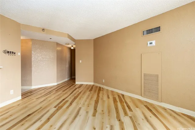 a view of an empty room with wooden floor