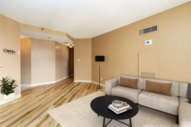 a living room with furniture and a wooden floor