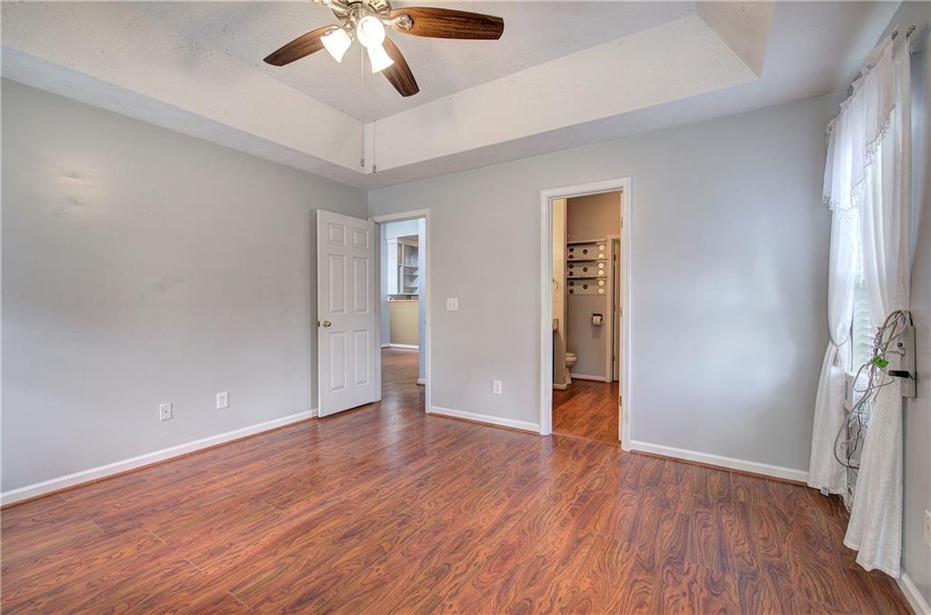 25 Haley Place, Unit 3 Cartersville, GA 30121 - Photo 19 of 45 an empty room with wooden floor chandelier fan and windows