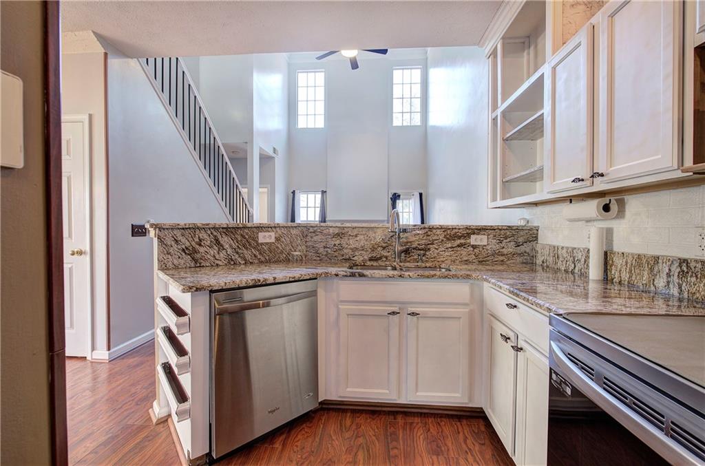 25 Haley Place, Unit 3 Cartersville, GA 30121 - Photo 8 of 45 a kitchen with granite countertop a sink stainless steel appliances white cabinets and wooden floor
