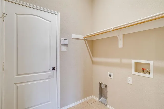 an empty room with chandelier fan and windows