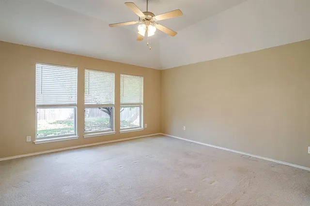 an empty room with closet and a ceiling fan