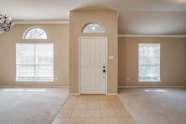 an empty room with wooden door windows and cabinet