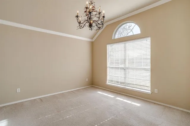a view of an empty room with a chandelier fan