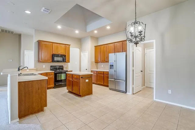 a kitchen with stainless steel appliances granite countertop a sink stove refrigerator and cabinets