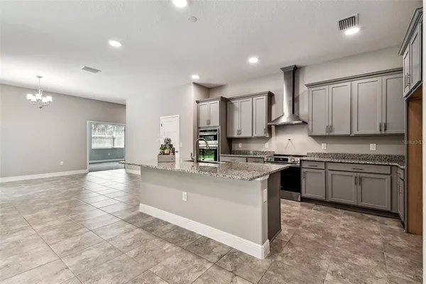 a large kitchen with stainless steel appliances granite countertop a sink stove and cabinets