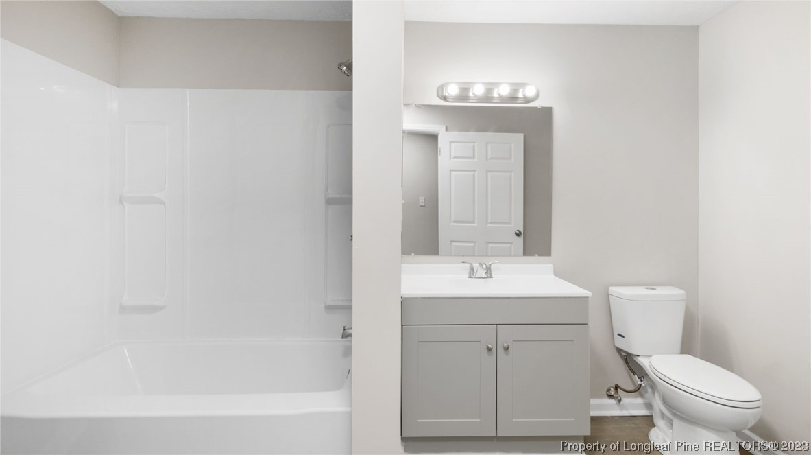6114 Sandy Creek Road Stedman, NC 28391 - Photo 21 of 34 a bathroom with a toilet a sink and mirror
