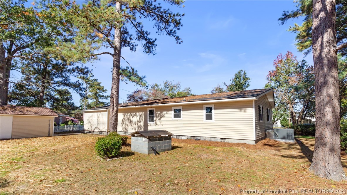 6114 Sandy Creek Road Stedman, NC 28391 - Photo 34 of 34 a view of a house with a backyard and a tree