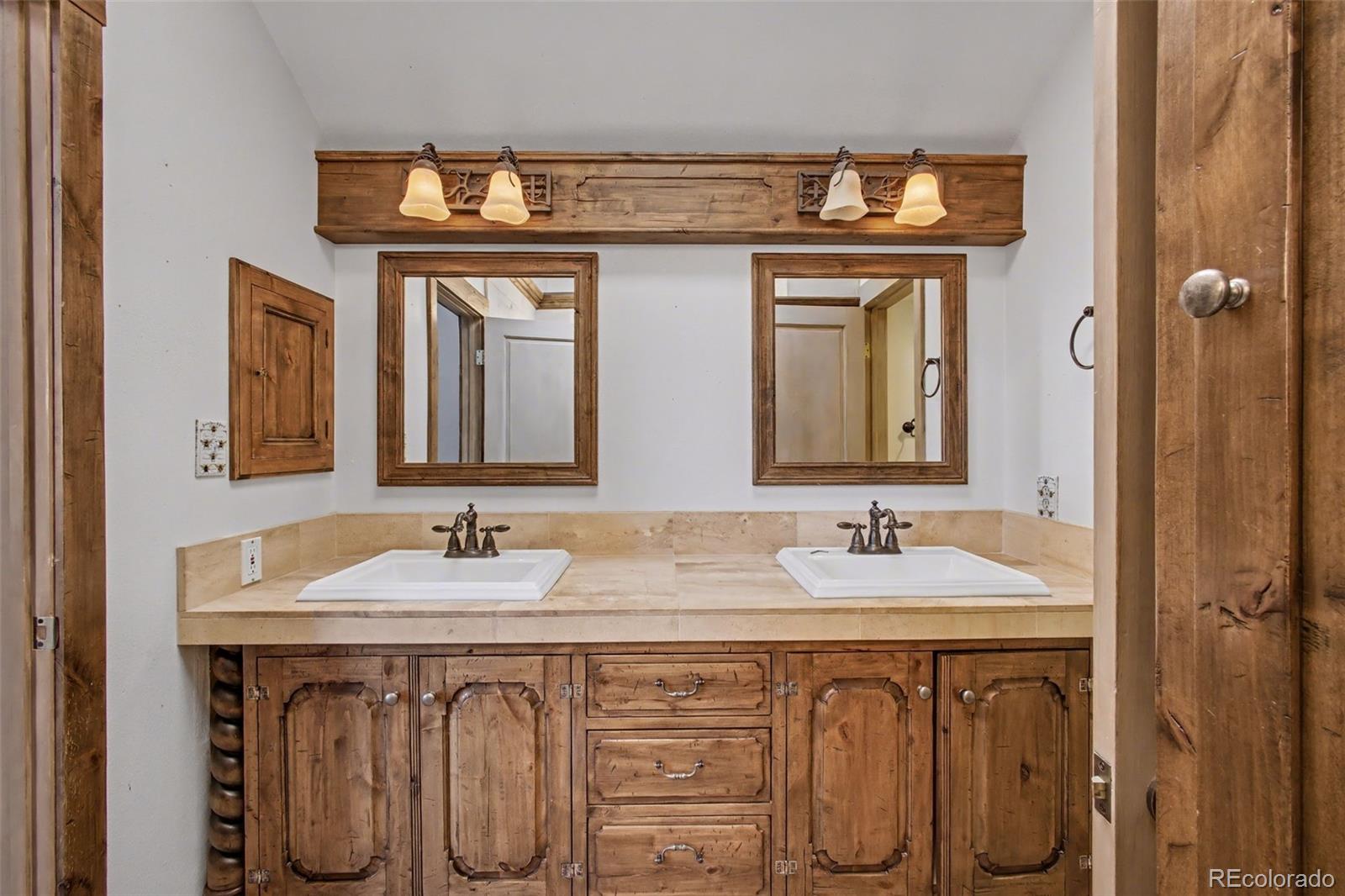 23666 Genesee Village Road Golden, CO 80401 - Photo 16 of 49 a bathroom with double sink and a mirror
