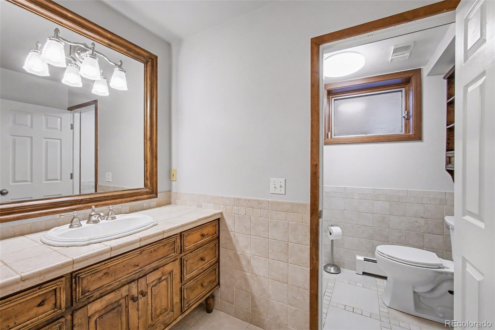 23666 Genesee Village Road Golden, CO 80401 - Photo 28 of 49 a bathroom with a sink a toilet and a mirror