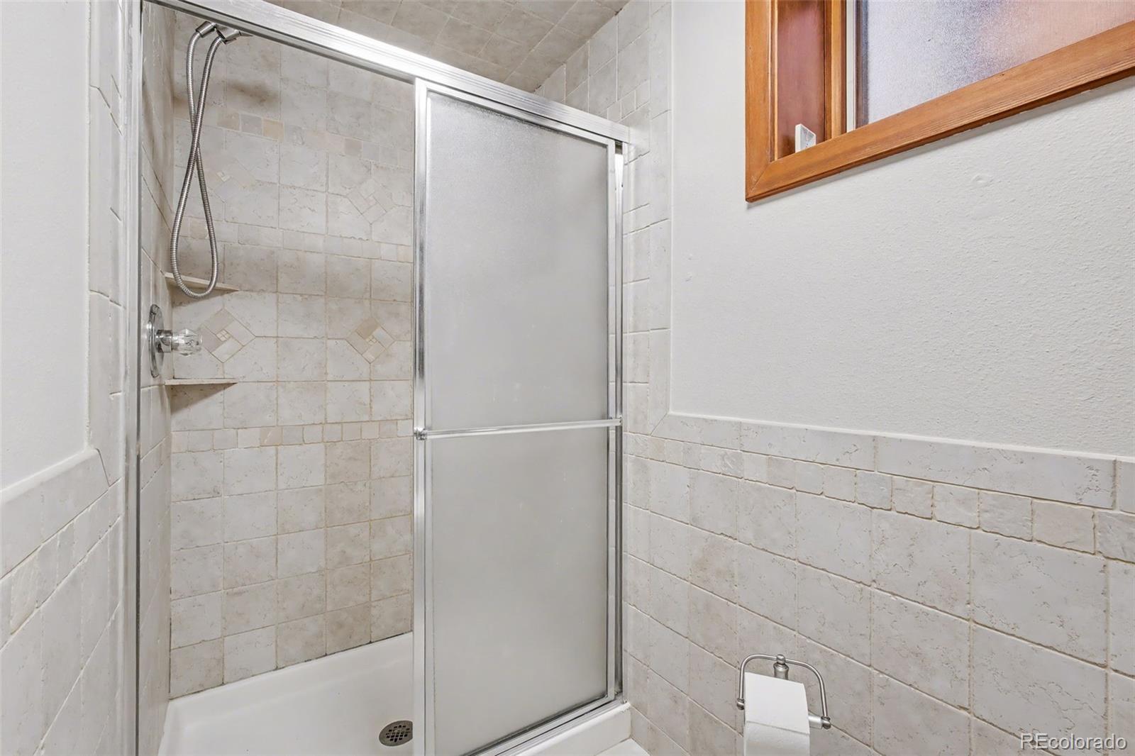 23666 Genesee Village Road Golden, CO 80401 - Photo 29 of 49 a bathroom with a glass shower door