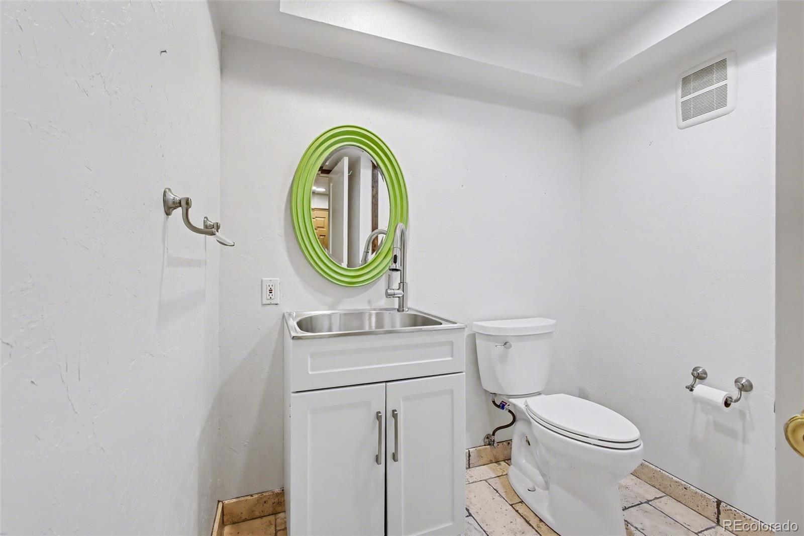 23666 Genesee Village Road Golden, CO 80401 - Photo 31 of 49 a bathroom with a toilet a sink and a mirror
