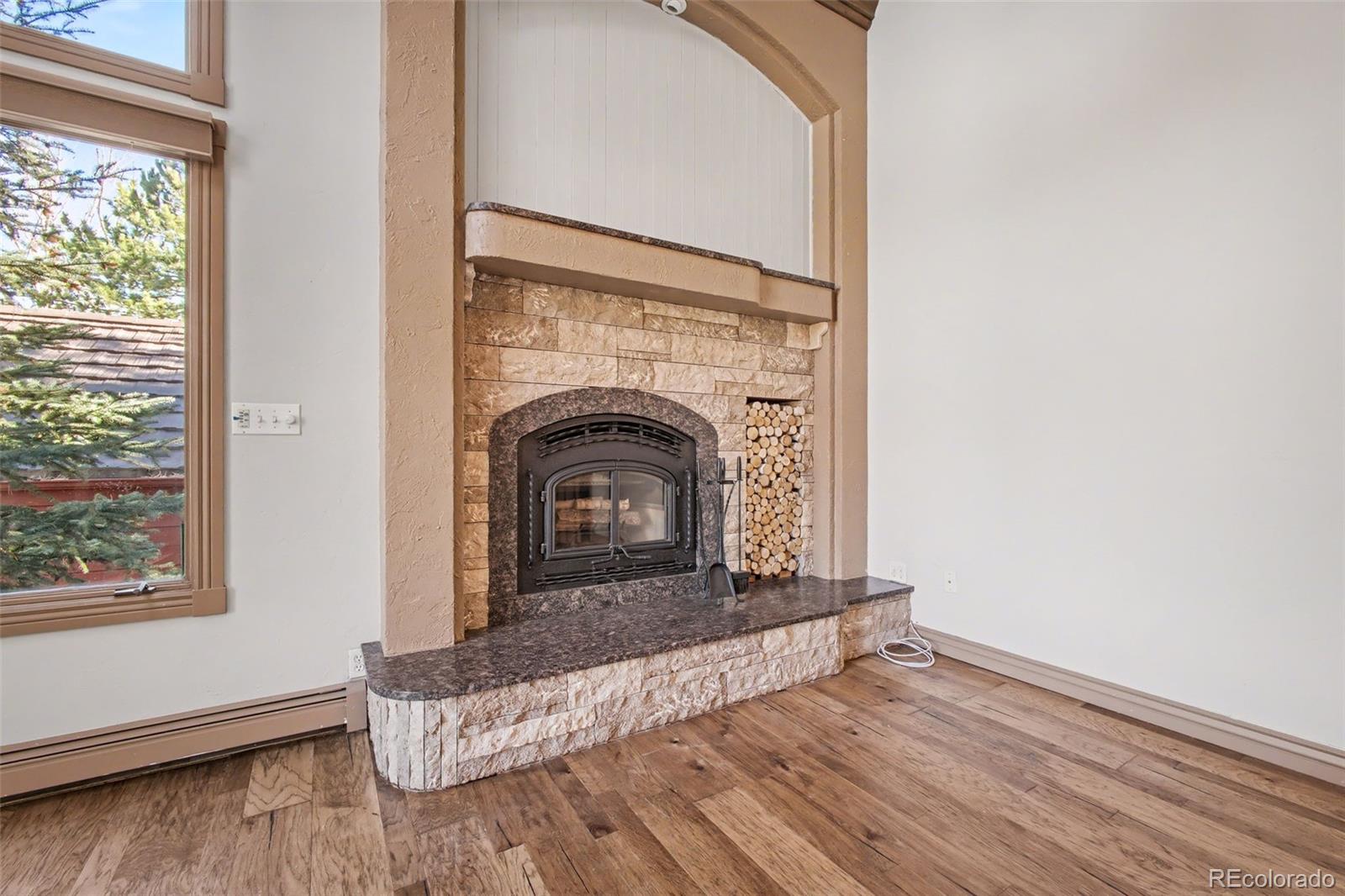 23666 Genesee Village Road Golden, CO 80401 - Photo 4 of 49 a living room with wooden floor and a fireplace