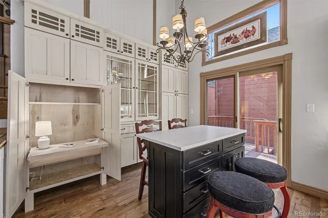 a view of a dining room with wooden floor and chandelier