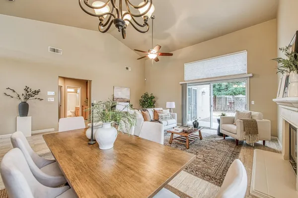 a living room with furniture dining table and a chandelier