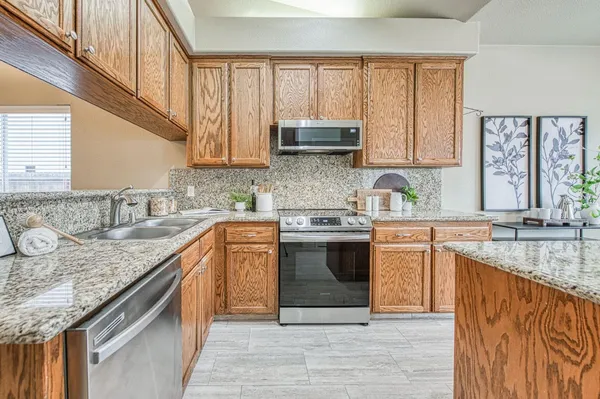 a kitchen with stainless steel appliances granite countertop a sink stove and cabinets
