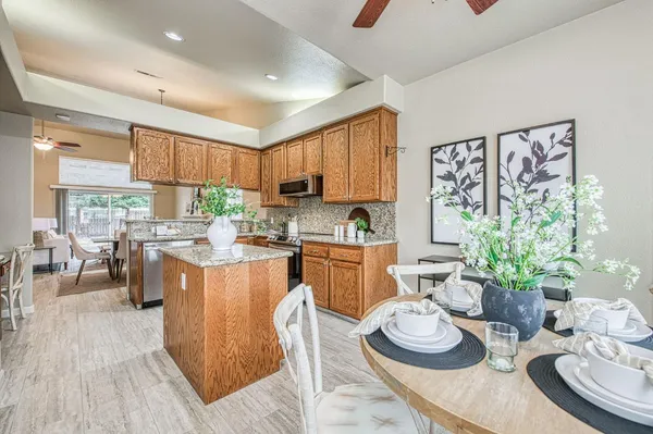 a kitchen with a table and chairs stove and white cabinets
