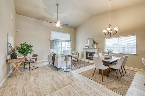 a dining room with wooden floor a chandelier a glass table and chairs