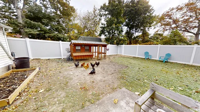 a backyard of a house with large trees and wooden fence