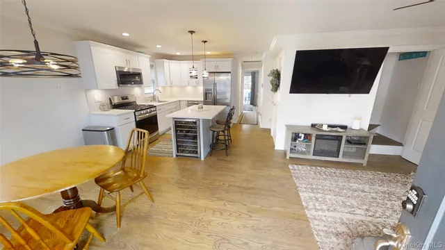 a living room with stainless steel appliances kitchen island granite countertop furniture and a flat screen tv