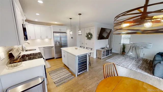 a kitchen with sink a refrigerator and chairs
