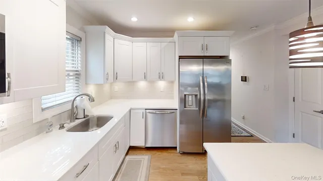 a kitchen with stainless steel appliances granite countertop a refrigerator a sink and a stove