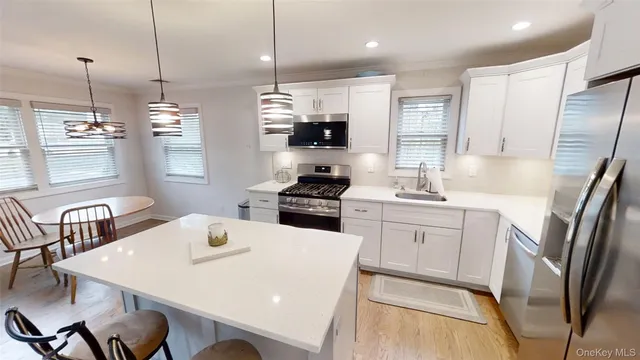 a kitchen with a refrigerator a sink a stove and chairs
