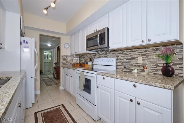 a kitchen with stainless steel appliances granite countertop a sink a stove and cabinets