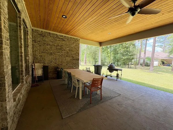 a dining room with furniture and a floor to ceiling window