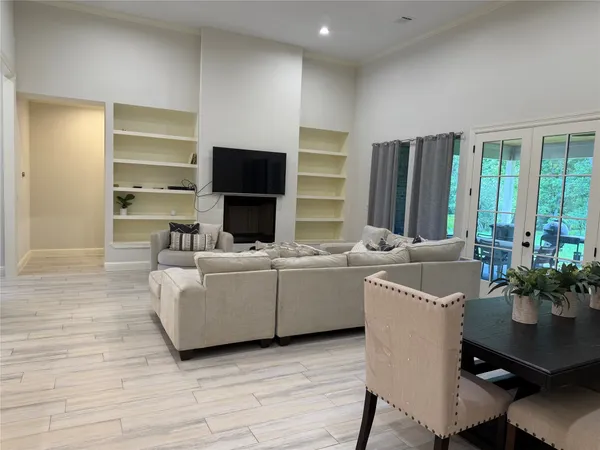 a living room with furniture a large window and a flat screen tv