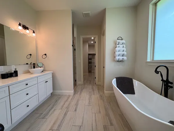 a bathroom with a double vanity sink a mirror and bathtub