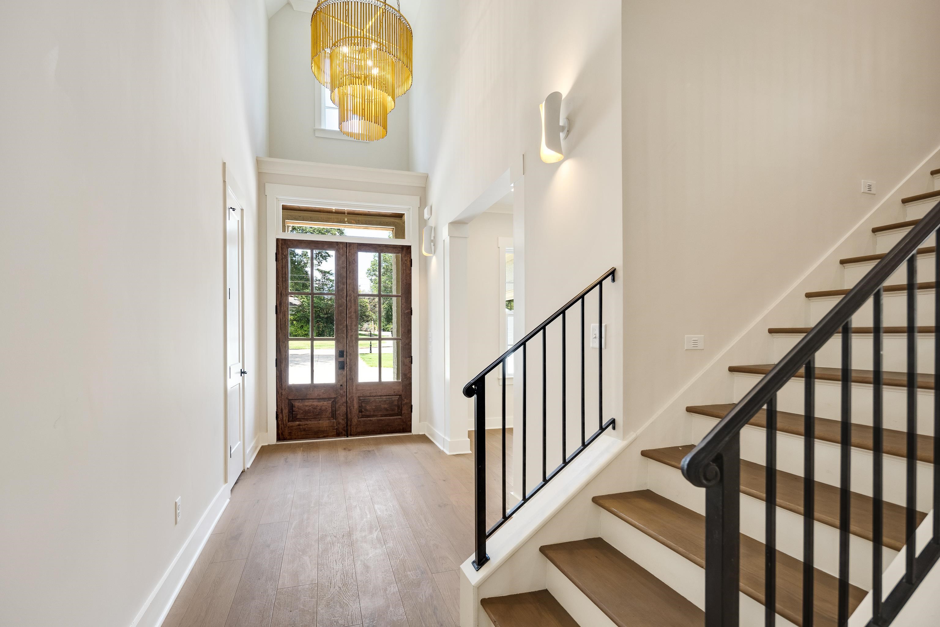 352 Avon Road Memphis, TN 38117 - Photo 4 of 26 Foyer entrance featuring french doors, light wood-style flooring, stairway, a towering ceiling, and a chandelier